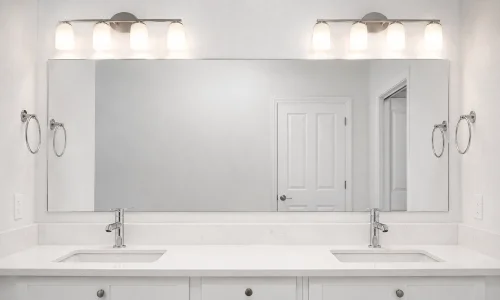 Custom-cut bathroom mirror above a vanity